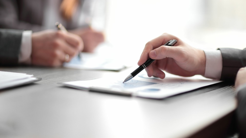 Hand och penna på ett avtal för en affär om onoterade bolag